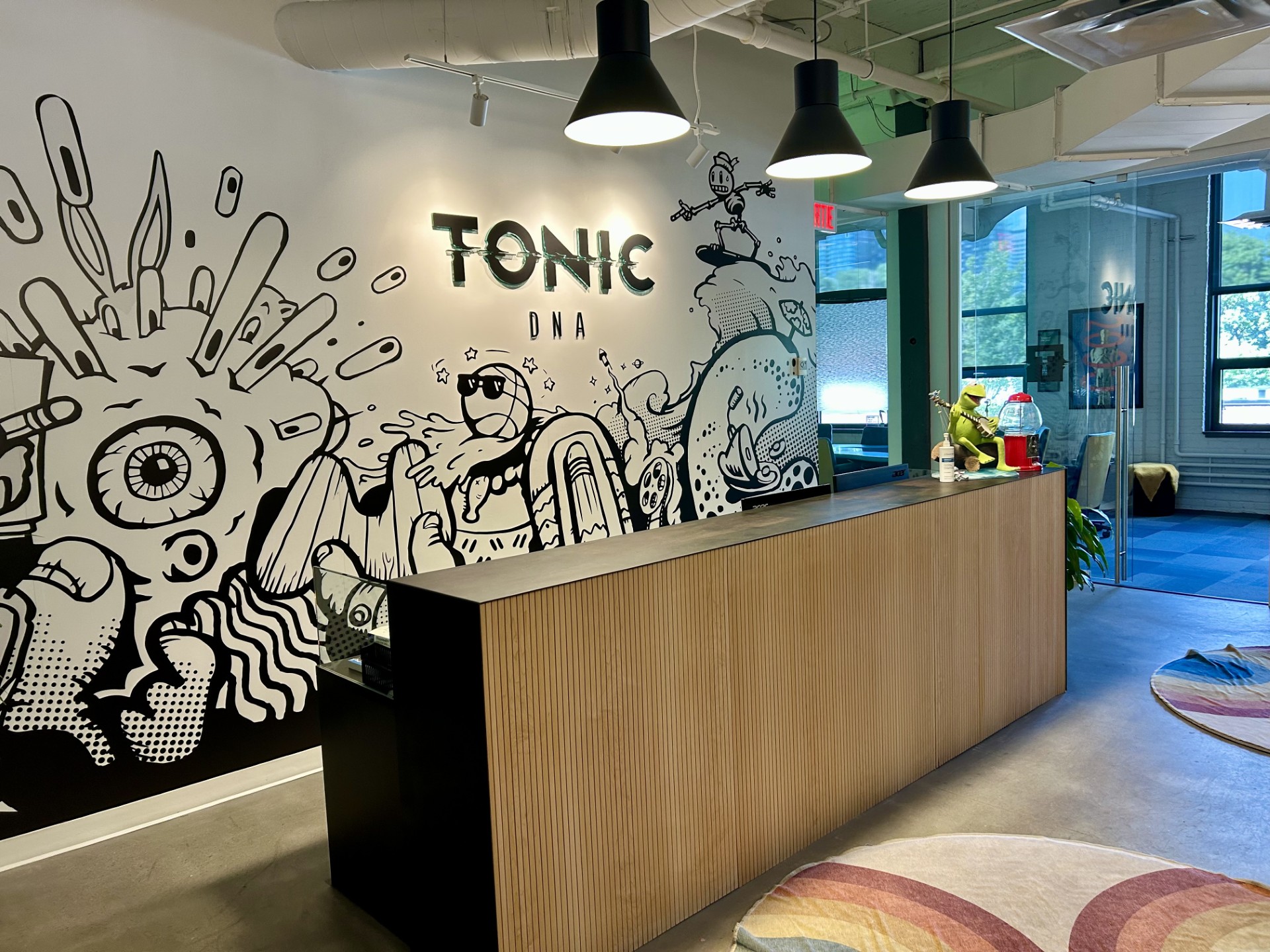 The reception at Tonic DNA, with a black and white mural behind the front desk
