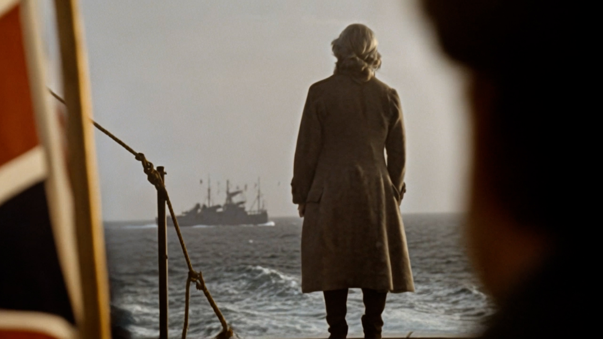 A man aboard a ship looks out to sea in TRANSIT.