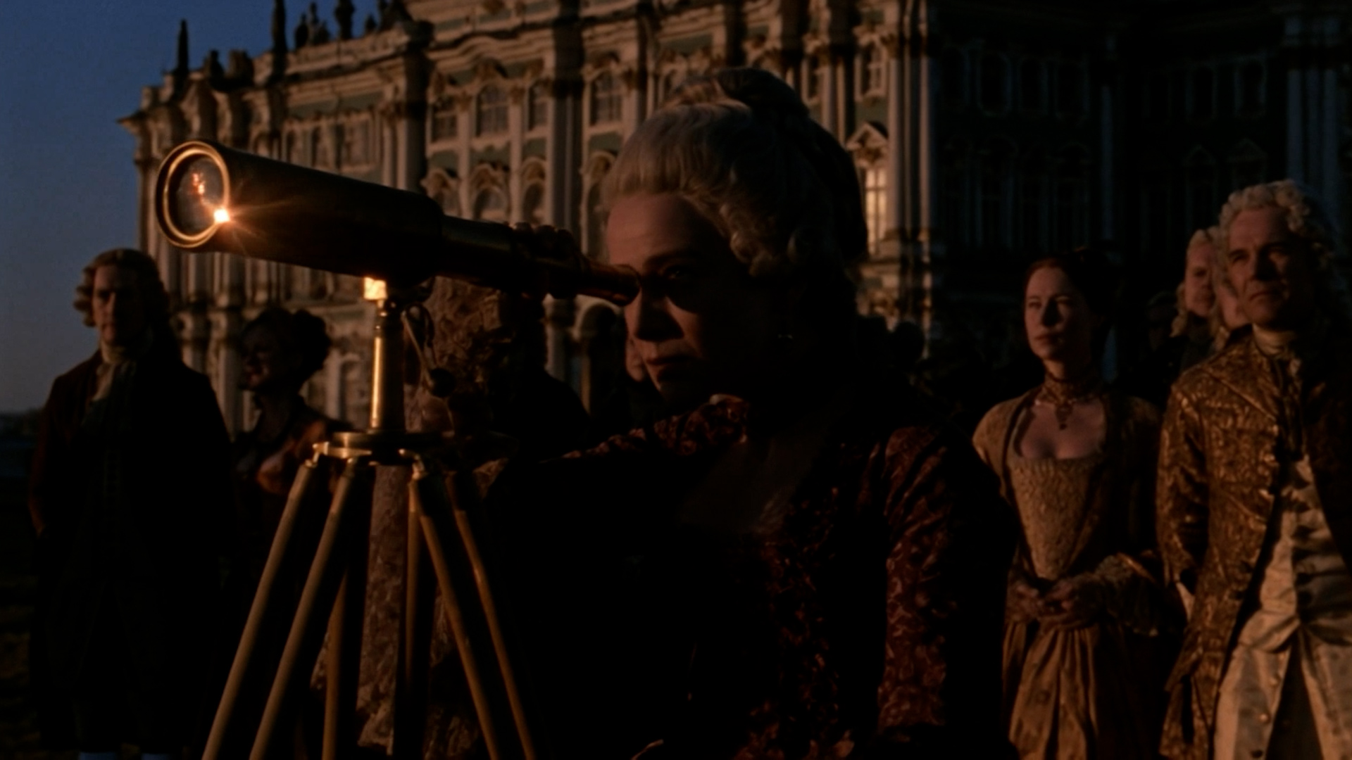 A woman looks through a telescope in TRANSIT.